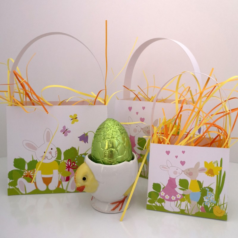 Paniers en papier pour cadeaux de Pâques décorés de motifs de lapins, d’œufs, de poussins, de papillons et de fleurs.